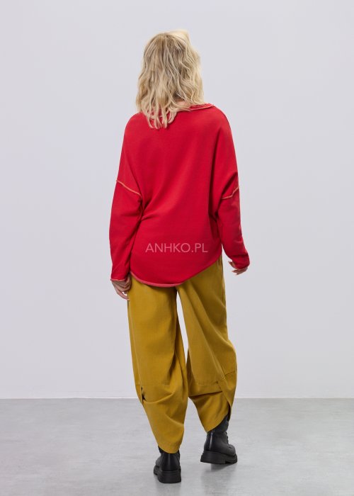 Czerwona bluza damska oversize z haftem „Milano 95” i kontrastowymi przeszyciami, zestawiona z musztardowymi spodniami w stylizacji miejskiej.