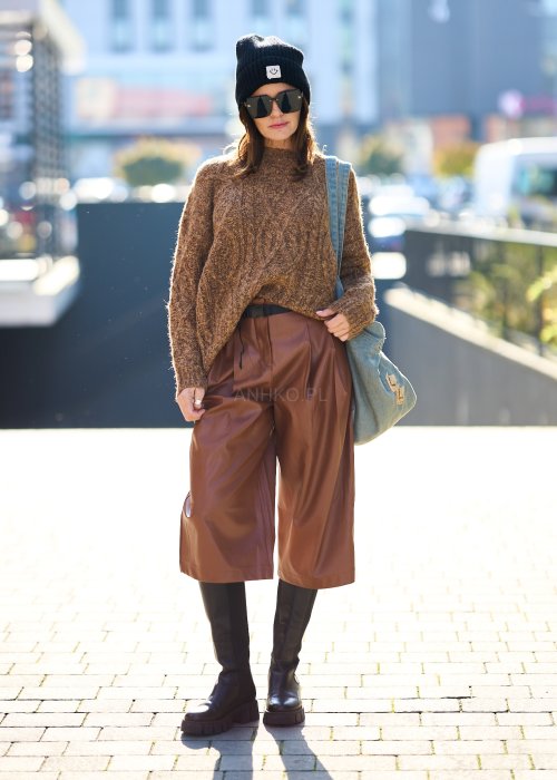 Brązowy sweter damski o grubym splocie z wyrazistym wzorem warkoczowym i luźnym krojem na chłodniejsze dni