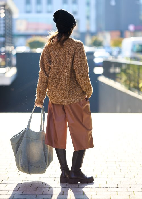 Brązowy sweter damski o grubym splocie z wyrazistym wzorem warkoczowym i luźnym krojem na chłodniejsze dni