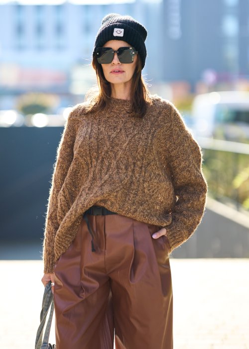 Brązowy sweter damski o grubym splocie z wyrazistym wzorem warkoczowym i luźnym krojem na chłodniejsze dni