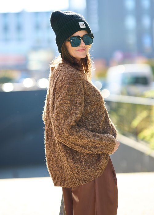 Brązowy sweter damski o grubym splocie z wyrazistym wzorem warkoczowym i luźnym krojem na chłodniejsze dni