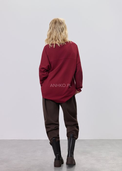 Brązowe spodnie sztruksowe o swobodnym kroju z elastyczną talią i kieszeniami zapinanymi na guziki, zestawione z botkami w stylizacji miejskiej.