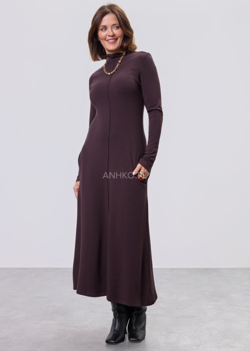 Długa śliwkowa sukienka maxi z długim rękawem i kieszeniami, stylizowana z czarnymi botkami.