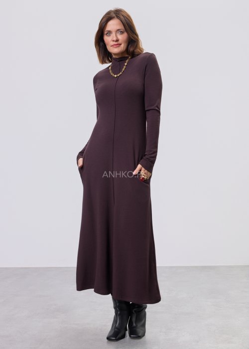 Długa śliwkowa sukienka maxi z długim rękawem i kieszeniami, stylizowana z czarnymi botkami.