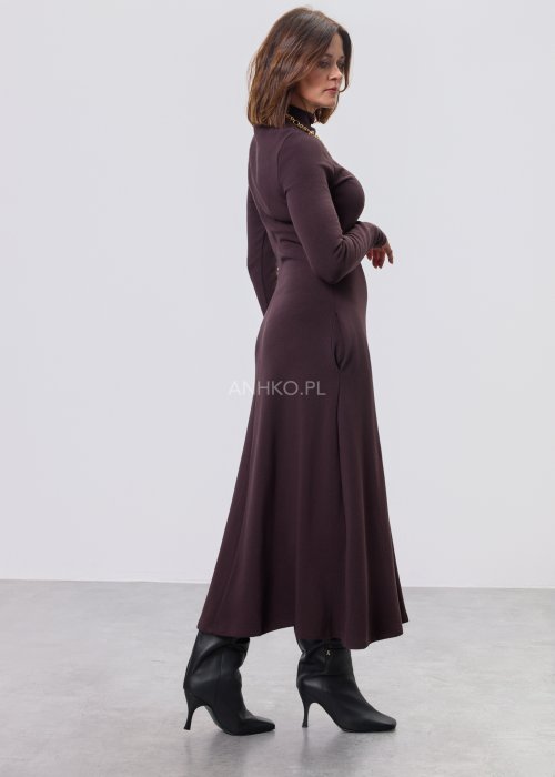 Długa śliwkowa sukienka maxi z długim rękawem i kieszeniami, stylizowana z czarnymi botkami.