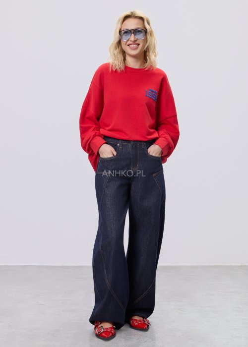 Czerwona bluza damska oversize z nadrukiem Since 1998 z przodu i okrągłą grafiką na plecach, stylizacja z szerokimi jeansami.