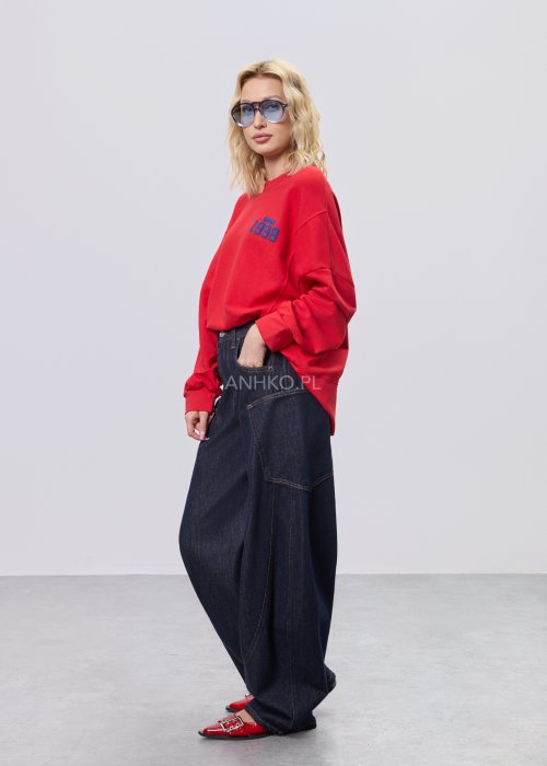 Czerwona bluza damska oversize z nadrukiem Since 1998 z przodu i okrągłą grafiką na plecach, stylizacja z szerokimi jeansami.