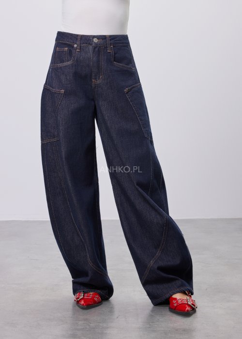 Granatowe jeansy damskie z szeroką nogawką i utility kieszeniami, ozdobne przeszycia, stylizacja z czerwonymi balerinami.