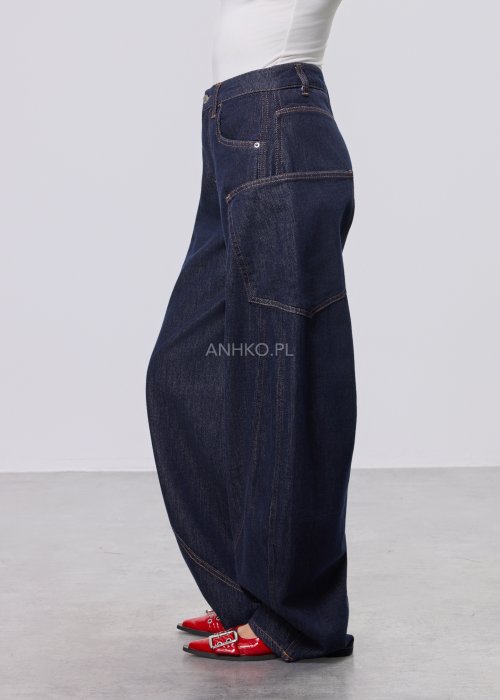 Granatowe jeansy damskie z szeroką nogawką i utility kieszeniami, ozdobne przeszycia, stylizacja z czerwonymi balerinami.