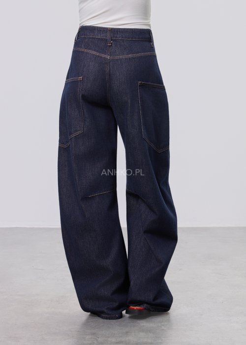 Granatowe jeansy damskie z szeroką nogawką i utility kieszeniami, ozdobne przeszycia, stylizacja z czerwonymi balerinami.