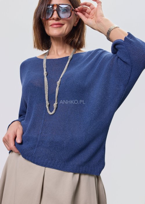 Granatowa bluzka damska z dekoltem V i luźnym fasonem, zestawiona z beżową spódnicą.