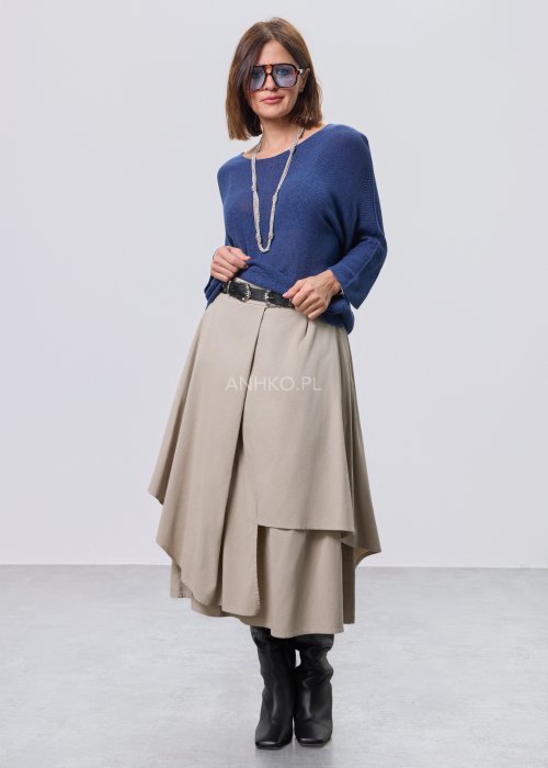 Beżowa spódnica midi o asymetrycznym, warstwowym kroju z elastycznym pasem i kieszeniami, stylizowana z kowbojkami.