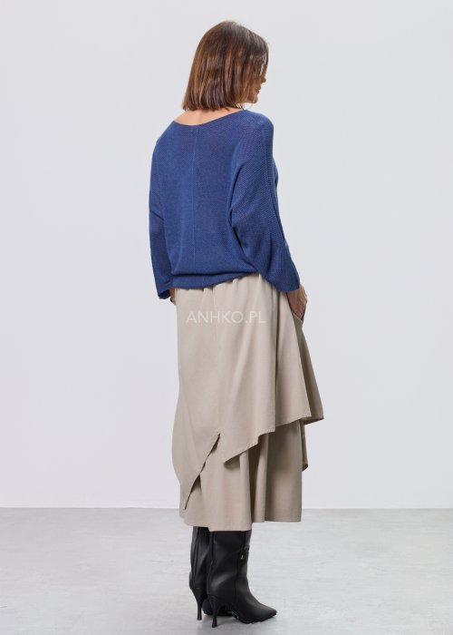 Beżowa spódnica midi o asymetrycznym, warstwowym kroju z elastycznym pasem i kieszeniami, stylizowana z kowbojkami.