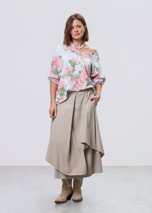 Beżowa spódnica midi o asymetrycznym, warstwowym kroju z elastycznym pasem i kieszeniami, stylizowana z kowbojkami.