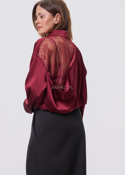Bordowa koszula damska z satynowym wykończeniem i koronkowym tyłem, zestawiona z czarną spódnicą o rozkloszowanym kroju.