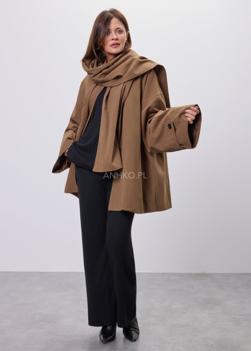 Krótki płaszcz damski w kolorze camel z paskiem i szerokim kołnierzem, stylizowany z czarnym kompletem dzianinowym i botkami.