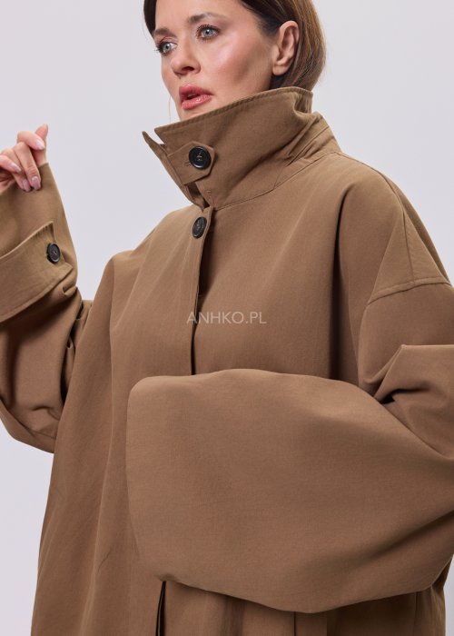 Krótki płaszcz damski w kolorze camel z paskiem i szerokim kołnierzem, stylizowany z czarnym kompletem dzianinowym i botkami.