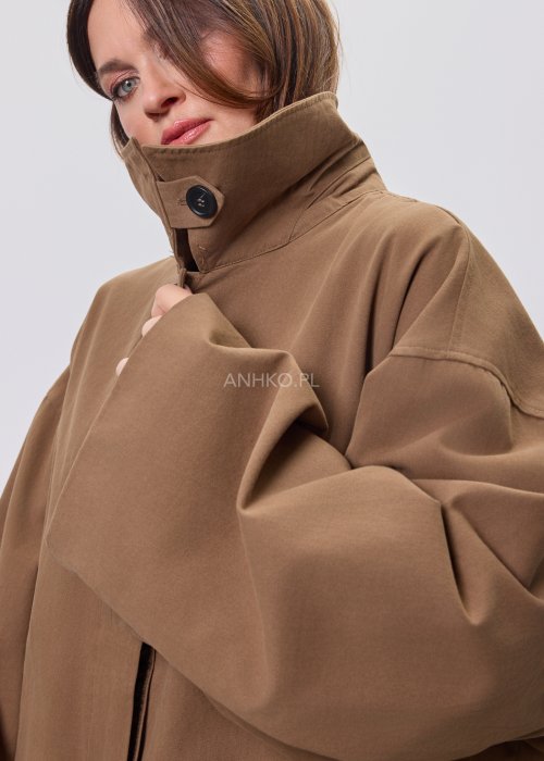 Krótki płaszcz damski w kolorze camel z paskiem i szerokim kołnierzem, stylizowany z czarnym kompletem dzianinowym i botkami.