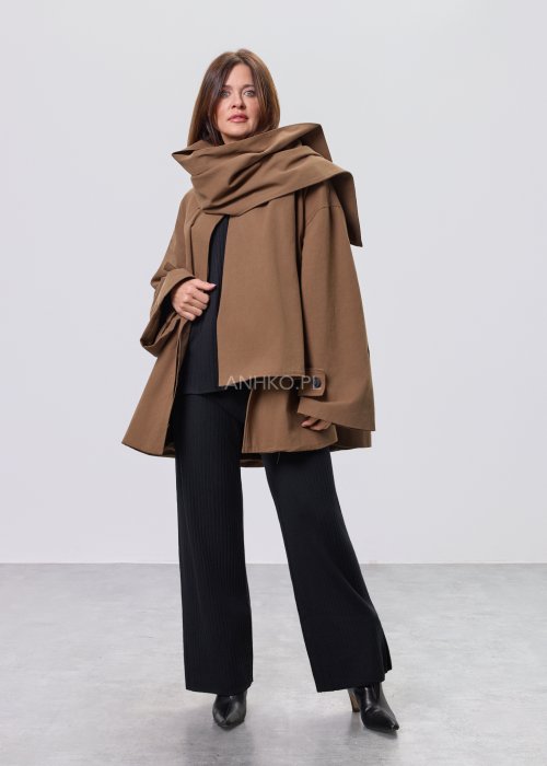 Krótki płaszcz damski w kolorze camel z paskiem i szerokim kołnierzem, stylizowany z czarnym kompletem dzianinowym i botkami.