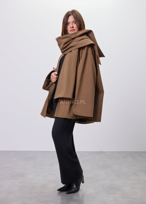 Krótki płaszcz damski w kolorze camel z paskiem i szerokim kołnierzem, stylizowany z czarnym kompletem dzianinowym i botkami.