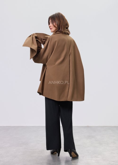 Krótki płaszcz damski w kolorze camel z paskiem i szerokim kołnierzem, stylizowany z czarnym kompletem dzianinowym i botkami.