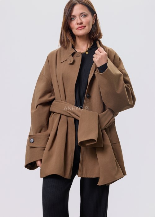 Krótki płaszcz damski w kolorze camel z paskiem i szerokim kołnierzem, stylizowany z czarnym kompletem dzianinowym i botkami.