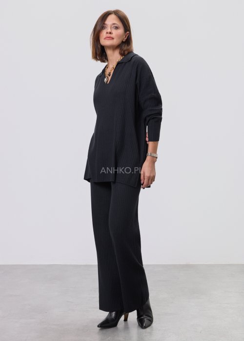 Czarny komplet dzianinowy z bluzką z dekoltem w serek i prostymi spodniami, stylizowany z czarnymi botkami.
