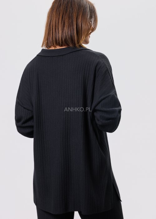 Czarny komplet dzianinowy z bluzką z dekoltem w serek i prostymi spodniami, stylizowany z czarnymi botkami.