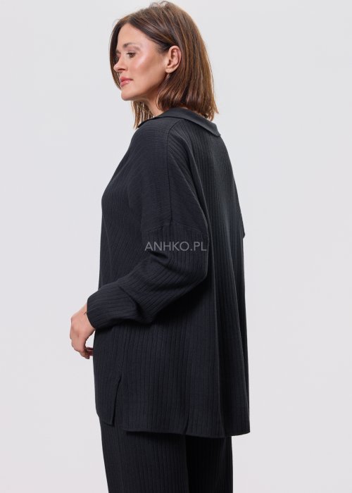 Czarny komplet dzianinowy z bluzką z dekoltem w serek i prostymi spodniami, stylizowany z czarnymi botkami.