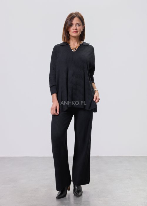 Czarny komplet dzianinowy z bluzką z dekoltem w serek i prostymi spodniami, stylizowany z czarnymi botkami.