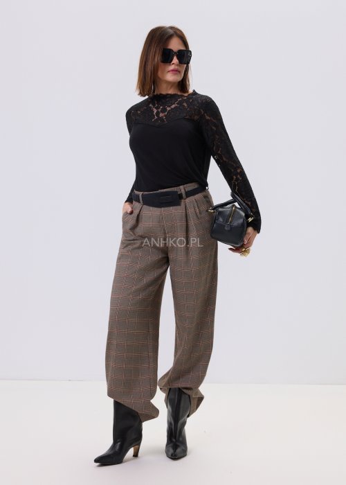 Czarna bluzka damska Lace Flow z koronkową górą i długimi rękawami oraz gładkim dołem, o klasycznym kroju, stylizowana z eleganckimi spodniami w kratę.