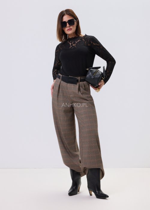 Czarna bluzka damska Lace Flow z koronkową górą i długimi rękawami oraz gładkim dołem, o klasycznym kroju, stylizowana z eleganckimi spodniami w kratę.