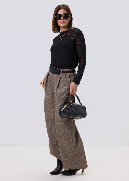 Czarna bluzka damska Lace Flow z koronkową górą i długimi rękawami oraz gładkim dołem, o klasycznym kroju, stylizowana z eleganckimi spodniami w kratę.
