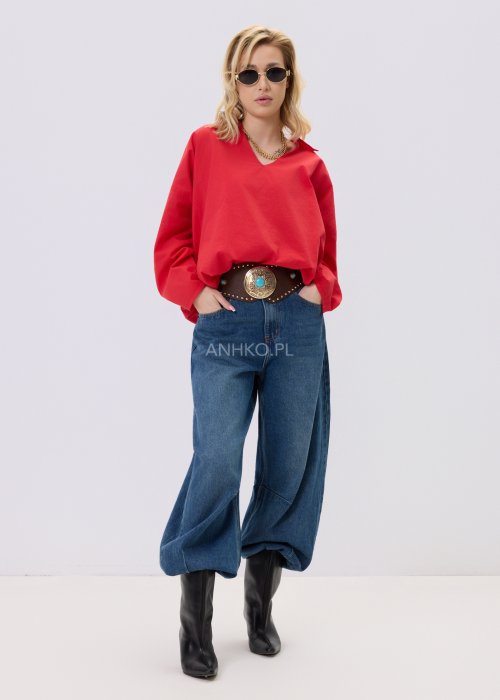 Czerwona bluzka damska The Calm o luźnym kroju z dekoltem V i podwijanymi rękawami, zestawiona z jeansami w stylizacji casualowej