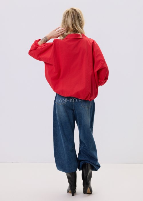 Czerwona bluzka damska The Calm o luźnym kroju z dekoltem V i podwijanymi rękawami, zestawiona z jeansami w stylizacji casualowej