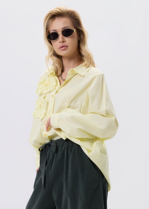 Żółta koszula damska Livia Quiet z ozdobnymi aplikacjami 3D na przodzie, o luźnym kroju, zestawiona z ciemnymi spodniami w stylizacji casualowej