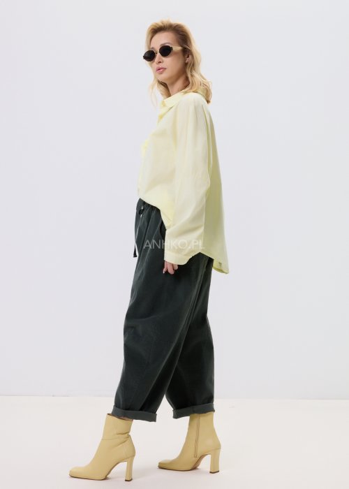 Żółta koszula damska Livia Quiet z ozdobnymi aplikacjami 3D na przodzie, o luźnym kroju, zestawiona z ciemnymi spodniami w stylizacji casualowej