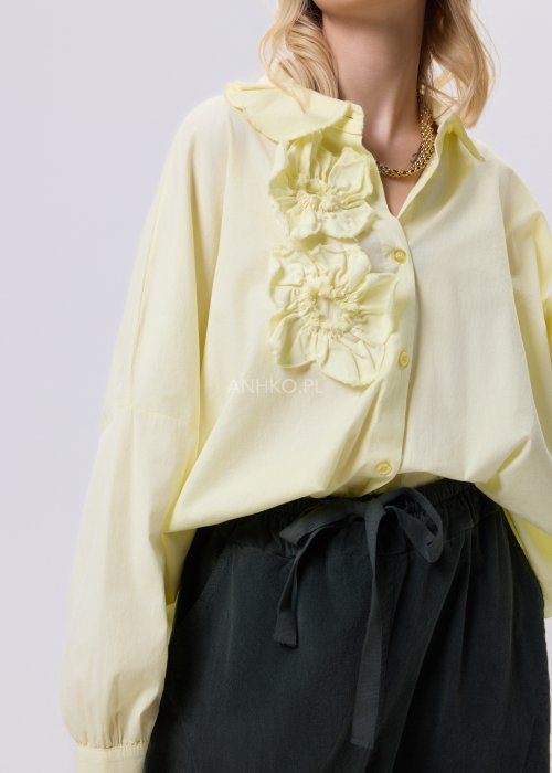 Żółta koszula damska Livia Quiet z ozdobnymi aplikacjami 3D na przodzie, o luźnym kroju, zestawiona z ciemnymi spodniami w stylizacji casualowej