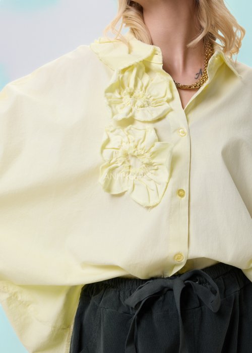 Żółta koszula damska Livia Quiet z ozdobnymi aplikacjami 3D na przodzie, o luźnym kroju, zestawiona z ciemnymi spodniami w stylizacji casualowej