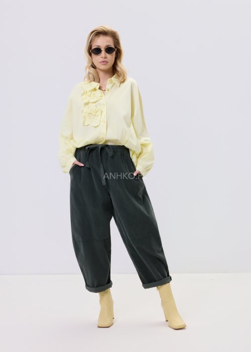 Żółta koszula damska Livia Quiet z ozdobnymi aplikacjami 3D na przodzie, o luźnym kroju, zestawiona z ciemnymi spodniami w stylizacji casualowej