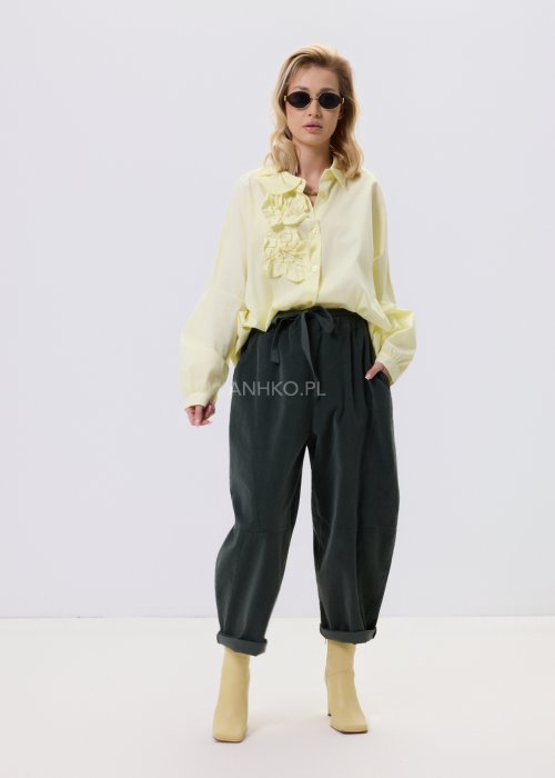 Żółta koszula damska Livia Quiet z ozdobnymi aplikacjami 3D na przodzie, o luźnym kroju, zestawiona z ciemnymi spodniami w stylizacji casualowej