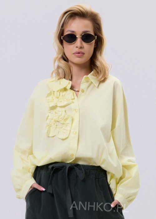 Żółta koszula damska Livia Quiet z ozdobnymi aplikacjami 3D na przodzie, o luźnym kroju, zestawiona z ciemnymi spodniami w stylizacji casualowej