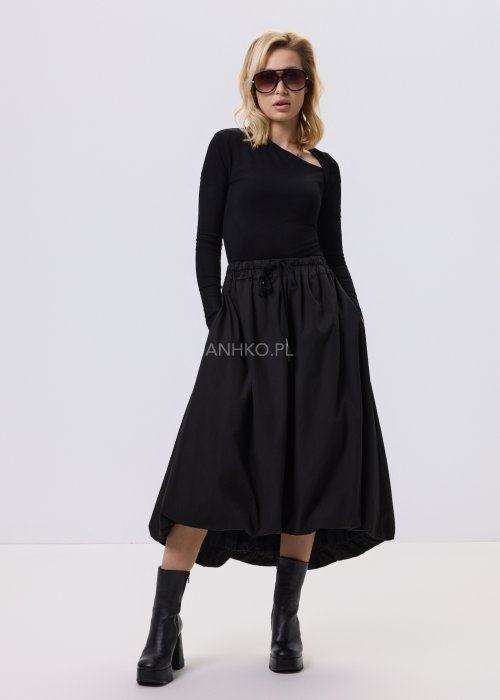 Czarna dopasowana bluzka damska z asymetrycznym dekoltem i długim rękawem, wykonana z elastycznego materiału, zestawiona z czarną spódnicą w nowoczesnej stylizacji.