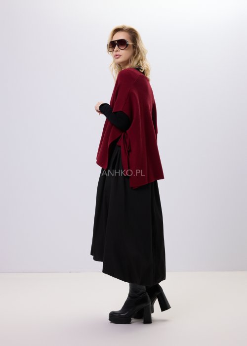 Bordowy bezrękawnik dzianinowy z bocznym wiązaniem i guzikami, noszony na czarnej bluzce w eleganckiej, warstwowej stylizacji