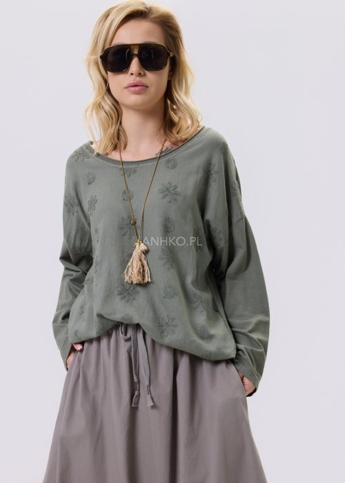 Khaki bluzka damska o luźnym kroju z subtelnym, wytłaczanym wzorem, zestawiona z szerokimi spodniami w casualowej stylizacji