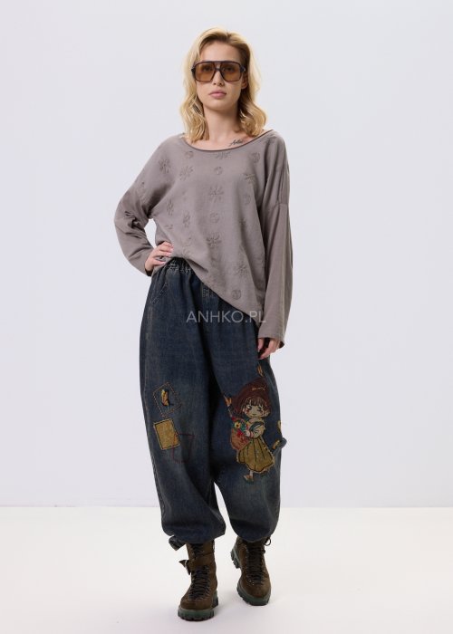 Bluzka damska w kolorze taupe z tłoczonym wzorem kwiatów i kropek, o luźnym kroju i długim rękawie, zestawiona z jeansami w casualowej stylizacji.