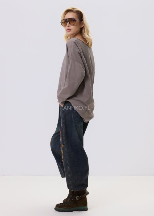 Bluzka damska w kolorze taupe z tłoczonym wzorem kwiatów i kropek, o luźnym kroju i długim rękawie, zestawiona z jeansami w casualowej stylizacji.