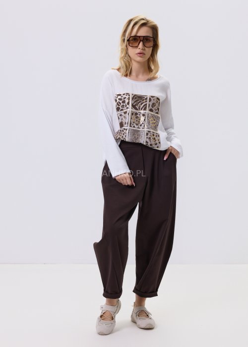 Ciemnobrązowe spodnie damskie Basco z szeroką nogawką zwężaną ku dołowi i gumką w pasie, zestawione ze sportowym obuwiem w stylizacji casualowej