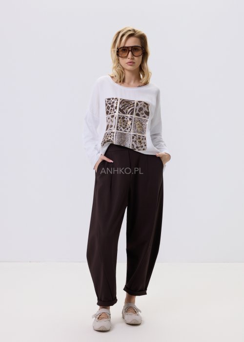 Ciemnobrązowe spodnie damskie Basco z szeroką nogawką zwężaną ku dołowi i gumką w pasie, zestawione ze sportowym obuwiem w stylizacji casualowej