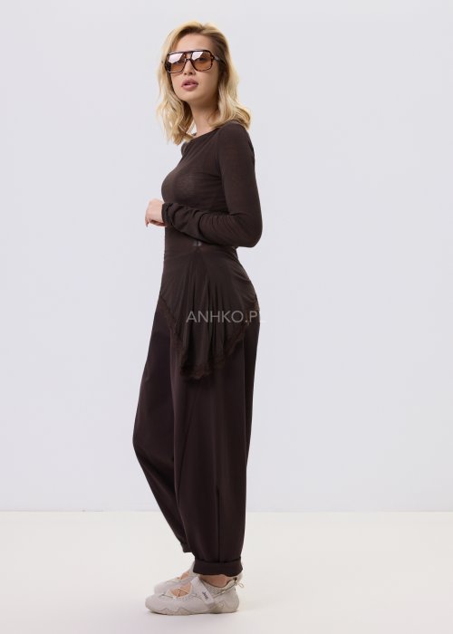 Ciemnobrązowe spodnie damskie Basco z szeroką nogawką zwężaną ku dołowi i gumką w pasie, zestawione ze sportowym obuwiem w stylizacji casualowej